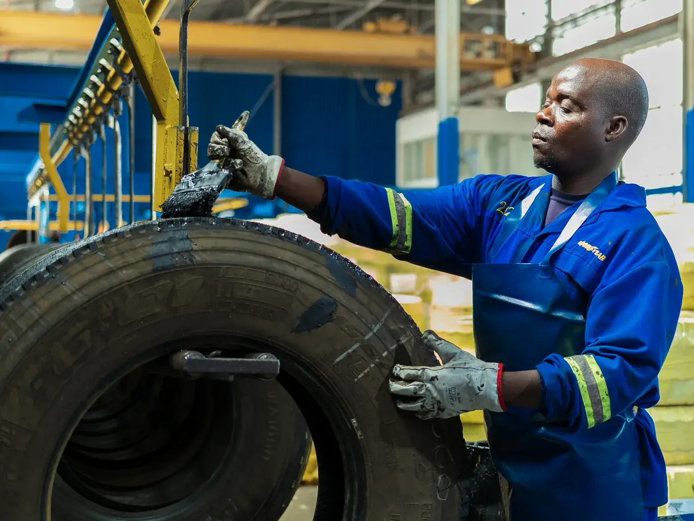 TrenTyre technician applying bonding cement to a tyre casing during retreading